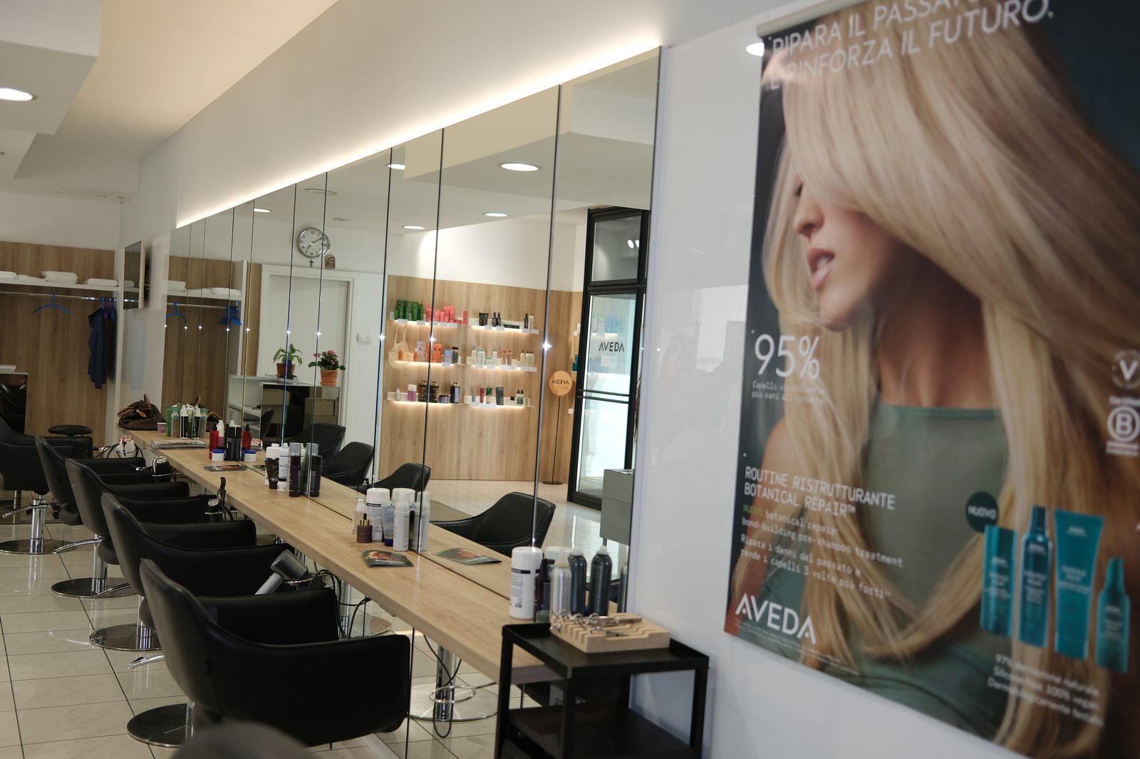 Interno del salone Brusco e Bellato a Pordenone con poltrone, specchi e l'espositore prodotti